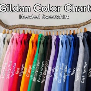 May include: A color chart for Gildan hooded sweatshirts, displaying a variety of colors. The image shows a range of hues, including white, pink, red, orange, green, blue, and black. The text "Gildan Color Chart Hooded Sweatshirt" is at the top.