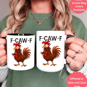 Pode incluir: Duas canecas de cerâmica branca com bordas e alças pretas. Cada caneca apresenta uma ilustração de galo de desenho animado e o texto "F-CAW-F". As canecas estão disponíveis nos tamanhos de 444ml e 325ml e em outras cores de destaque.
