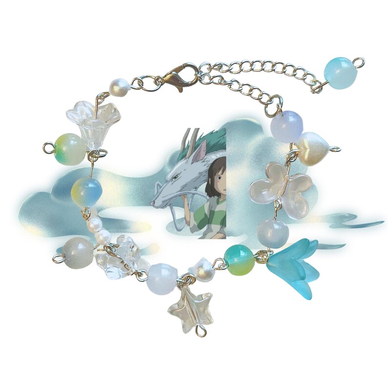 May include: A delicate bracelet featuring a mix of beads in white, blue, and green. The bracelet includes flower and star charms, with a silver chain and clasp. The background features an illustration of a dragon and a girl.