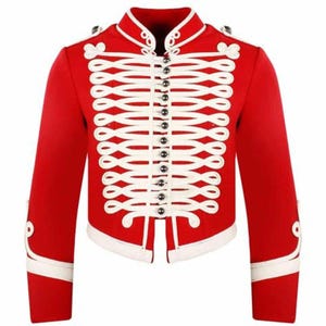 Puede incluir: Chaqueta roja de estilo militar con ribetes blancos y detalles decorativos de cuerda blanca. La chaqueta presenta un cuello alto, pequeños botones negros y detalles blancos en las mangas. Prenda de vestir elegante.