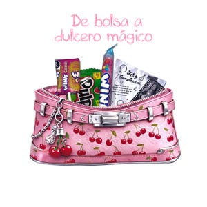 May include: A pink handbag with a cherry pattern, filled with candy and a birthday card. The bag has silver hardware and a charm with cherries. Text above the bag reads "De bolsa a dulcero m&aacute;gico".