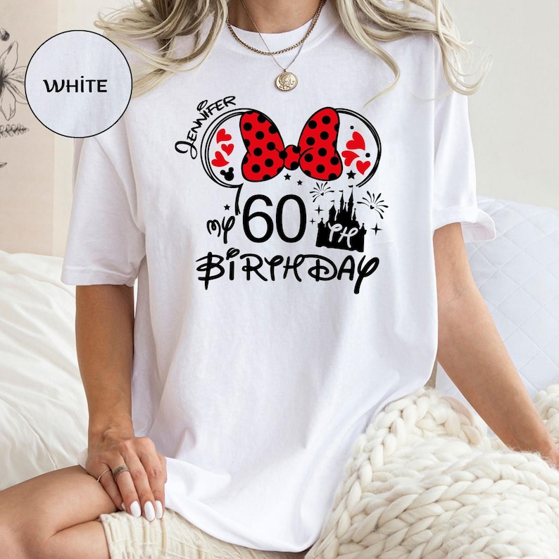 Puede incluir: Camiseta blanca con un dise&ntilde;o tem&aacute;tico de Minnie Mouse para un 60 cumplea&ntilde;os. El dise&ntilde;o incluye un lazo rojo de lunares, corazones, el nombre "Jennifer" y las palabras "my 60th Birthday" en negro.