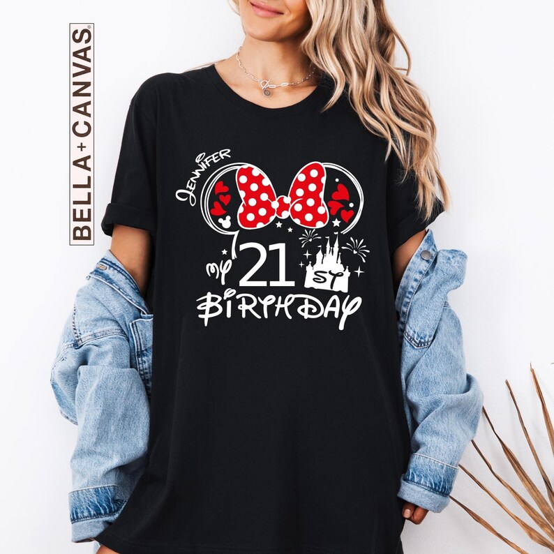May include: Black t-shirt with a Minnie Mouse-themed design for a 21st birthday. The design includes a red and white polka dot bow, hearts, fireworks, and a castle. The name "Jennifer" is written above the bow.