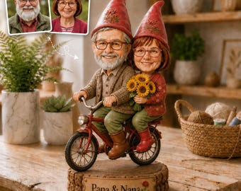 May include: A custom figurine of an older couple depicted as gnomes riding a red bicycle. The male gnome wears a brown cardigan and red hat, while the female gnome wears a red cardigan and red hat, holding sunflowers. A plaque reads Papa & Nana.