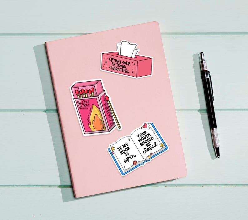 May include: Four pink and white stickers with book-themed sayings. The stickers feature a book, a box of matches, a tissue box, and a box of matches. The text on the stickers reads: "If my book is open, your mouth should be closed", "Slow Burn", "Crying over fictional characters", and "Glow Burn".