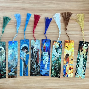May include: A collection of eight rectangular bookmarks with colorful illustrations and matching tassels. The designs include a sword, a castle, a figure in blue, a dragon, a white tiger, a bird, a woman, and a woman with a flower.