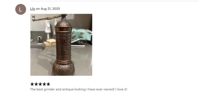 May include: An antique-style pepper grinder with a copper finish. The grinder features intricate embossed patterns and a crank handle. The design is reminiscent of vintage kitchen tools. The pepper grinder is a kitchen utensil.