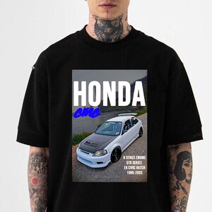 May include: Black t-shirt featuring a graphic of a white Honda Civic hatchback with a black hood. The text "HONDA" is above the car, with "Civic" in blue below. Additional text includes "B SERIES ENGINE 6TH SERIES EK CIVIC HATCH 1996-2000".