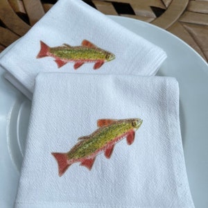 May include: Two white cotton tea towels with a brown, green, and red trout fish illustration printed on each.