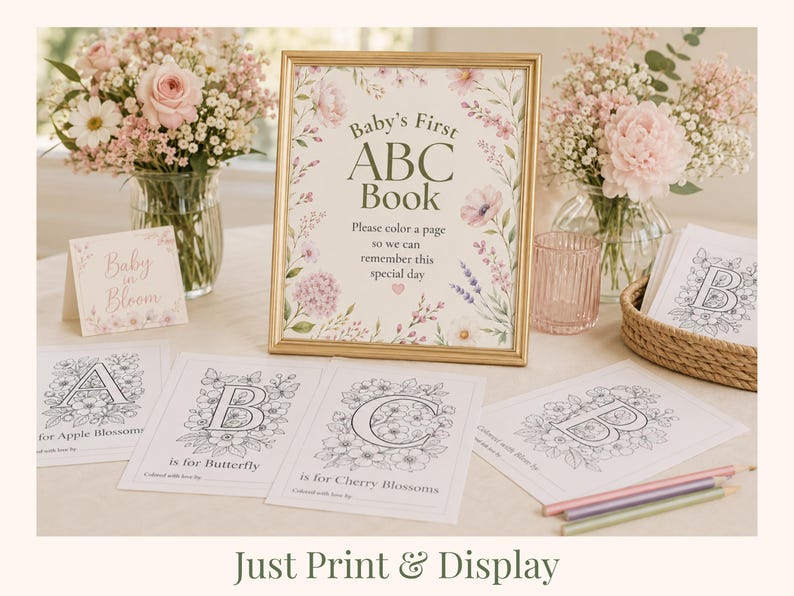 Baby in Bloom baby shower table setup featuring Baby’s First ABC Book sign with floral alphabet coloring pages for guests to color during the shower. Elegant blush pink floral baby shower activity with printable ABC keepsake book, coloring pages A–Z, and baby shower table decor. Printable baby shower game and interactive guest activity for creating a personalized keepsake for baby.