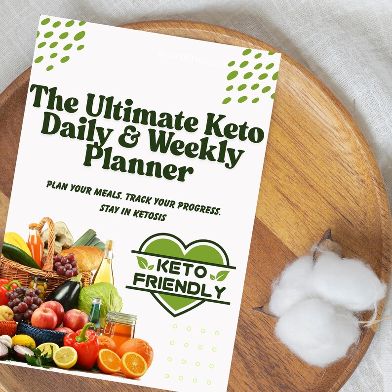 May include: A white printable planner with green text that reads "The Ultimate Keto Daily & Weekly Planner". The text "PLAN YOUR MEALS. TRACK YOUR PROGRESS. STAY IN KETOSIS" is also included. A green heart with the text "KETO FRIENDLY" is in the lower right corner. A basket of colorful fruits and vegetables is in the lower left corner.
