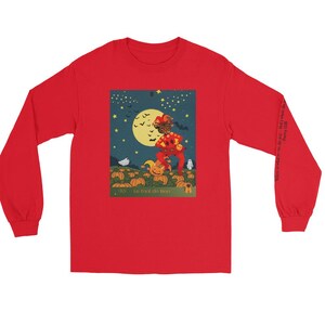 May include: A long-sleeved red shirt featuring a Halloween-themed graphic. The graphic depicts a figure in a jester costume with a pumpkin head, set against a night sky with a full moon and pumpkins. Text on the shirt reads "As I toil de Boo".