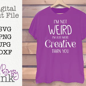 Puede incluir: Una camiseta morada con el texto blanco I'M NOT WEIRD I'M JUST MORE Creative THAN YOU. La imagen incluye el texto Digital Cut File, SVG, PNG, JPG, DXF y Whimsy Ink, indicando un archivo de diseño digital para manualidades.