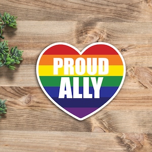 May include: A rainbow heart-shaped sticker with the words "Proud Ally" in white text.
