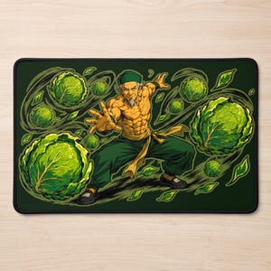 Puede incluir: Una alfombrilla de escritorio rectangular que muestra a un personaje mayor y musculoso con perilla, que lleva una gorra verde y pantalones verde oscuro, en una pose de artes marciales rodeado de repollos verdes y hojas flotantes.
