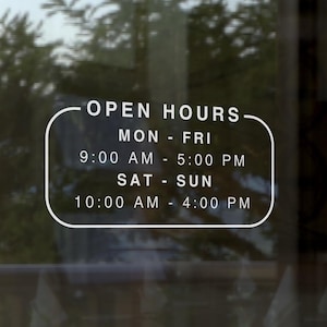 May include: A glass door with a white sign displaying business hours. The sign reads "OPEN HOURS" with the days and times: Mon-Fri 9:00 AM - 5:00 PM, Sat-Sun 10:00 AM - 4:00 PM. A gold-colored door handle is visible.