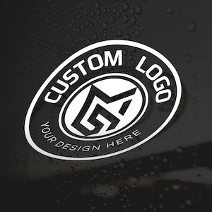 Peut inclure: Un autocollant ovale blanc avec une bordure noire portant le texte CUSTOM LOGO en haut et YOUR DESIGN HERE en bas. Au centre, un emblème géométrique noir audacieux est affiché sur un fond blanc à l'intérieur de l'ovale.