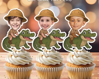 May include: Three personalized cupcake toppers featuring a cartoon image of a child wearing a safari hat and riding a green alligator. The toppers are printed on 8.5 x 11 inch paper and are a digital download.