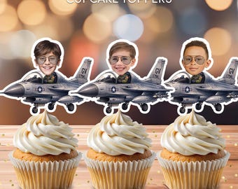 May include: Three cupcakes topped with personalized cutouts featuring a person's head on a fighter jet. The text reads Personalized CUPCAKE TOPPERS and PHYSICAL TOPPERS | APPROX. 3 INCH WIDE IMAGE. The jet is grey with a star emblem.