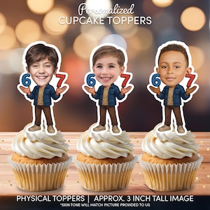 May include: Three cupcakes topped with personalized cartoon figures holding the numbers 6 and 7. The figures are approximately 3 inches tall. The cupcakes have white frosting and sit on a wooden surface. The text "Personalized CUPCAKE TOPPERS" is at the top.