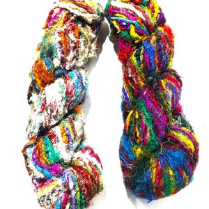 Puede incluir: Dos ovillos de hilo colorido, multicolor, hilado a mano. El hilo está hecho de seda sari reciclada y es perfecto para tejer o hacer ganchillo.