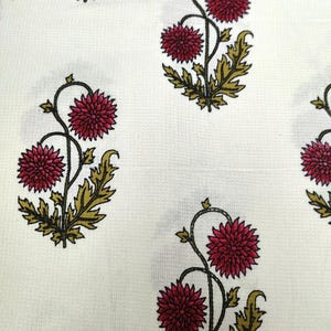 May include: White fabric with a repeating pattern of red and green floral designs. The flowers are stylized and have a vintage look.