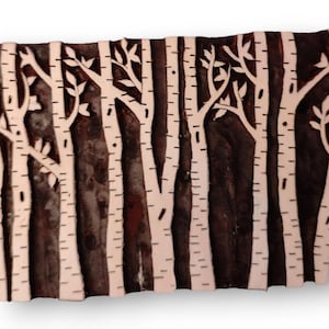 May include: A wooden printing block with a design of a birch tree forest. The block is carved with white birch trees and branches against a dark brown background.