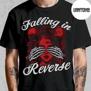 May include: Black t-shirt with a graphic design featuring a woman's face, skeleton hands, and the words "Falling in Reverse" in white script. The design includes red and white elements.