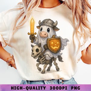May include: A cream-colored t-shirt featuring a cartoon cow dressed as a knight holding a golden sword and a shield with a jack-o'-lantern face. The cow is riding a skeleton horse. The text "HIGH-QUALITY 300DPI PNG" is at the bottom.