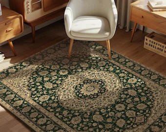 May include: A room featuring a green and beige patterned rug with a central medallion design. The room also includes a white chair, wooden furniture, and framed artwork. The rug's pattern has floral motifs.