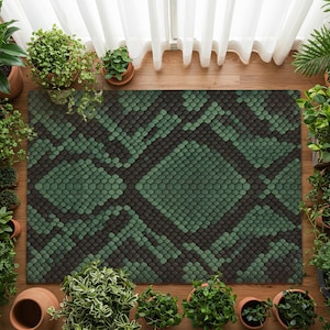Könnte beinhalten: Ein rechteckiger Teppich mit einem grünen und schwarzen Schlangenhautmuster. Der Teppich ist von Topfpflanzen umgeben, die eine natürliche und dekorative Umgebung schaffen. Das Design des Teppichs weist ein sich wiederholendes schuppenartiges Muster auf.