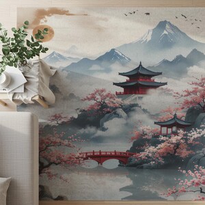 May include: A rug featuring a Japanese landscape scene with a red pagoda, bridge, and cherry blossoms. The design includes mountains, a lake, and a soft color palette of blues, reds, and pinks.