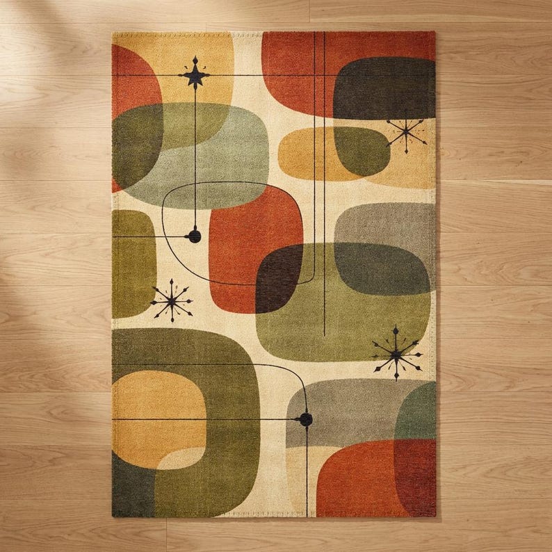 May include: A rectangular area rug with a mid-century modern design. The rug features rounded shapes in shades of green, orange, yellow, and gray on a cream background. Black lines and starburst details add to the retro aesthetic.