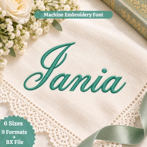Puede incluir: Una servilleta de tela blanca con borde de encaje festoneado presenta el nombre Jania bordado en letra cursiva verde. La imagen incluye etiquetas de texto que dicen Machine Embroidery Font, 6 Sizes, 9 Formats + BX File, junto a flores blancas y una cinta verde.