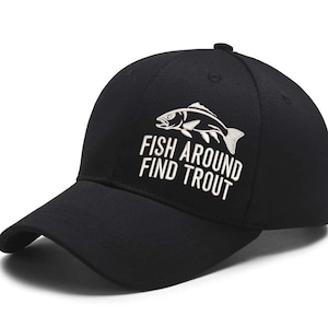 Op de afbeelding: Zwarte baseballcap met een gebogen klep. De cap heeft witte geborduurde tekst en een visafbeelding met de tekst "FISH AROUND FIND TROUT". Een klassieke stijl, geschikt voor buitenactiviteiten.