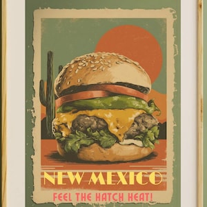 Puede incluir: Póster enmarcado de estilo vintage con una gran hamburguesa con pan de semillas de sésamo, tomate, lechuga y queso fundido. El póster tiene un diseño retro con el texto "NEW MEXICO FEEL THE HATCH HEAT!" y un paisaje desértico.