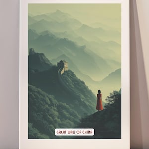 Op de afbeelding: Een ingelijste print met de Chinese Muur. Het kunstwerk toont een persoon in een rode jurk op een berg, met de muur en een mistig landschap op de achtergrond. De tekst "GREAT WALL OF CHINA" staat onderaan.