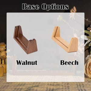 May include: Image showing two wooden base options: walnut and beech. The walnut base is a dark brown, while the beech base is a light tan. Both bases have a similar U-shaped design with a flat bottom and two vertical supports.
