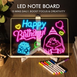 May include: LED note board with the text "Happy Birthday!" in neon colors. The board features a gift box, a girl with a party hat, and other celebratory graphics. Includes a set of colorful markers and a white stand.