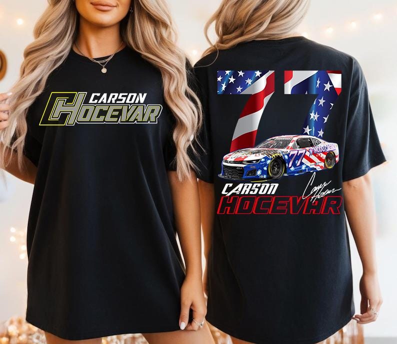 Op de afbeelding: Zwart T-shirt met de tekst "CARSON HOCEVAR" in geel en grijs op de voorkant. De achterkant van het shirt heeft een raceauto-ontwerp met het nummer 77 en de tekst "CARSON HOCEVAR" in rood en wit.