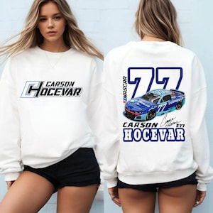 May include: White sweatshirt featuring the text "CARSON HOCEVAR" in a blue and black design on the front. The back displays a blue race car graphic with the number "77" and the name "CARSON HOCEVAR" in blue.