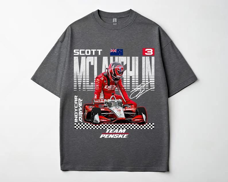 May include: Dark gray t-shirt featuring a graphic of a race car and driver in a red racing suit. The shirt includes the text "SCOTT McLAUGHLIN" and "INDYCAR DRIVER" with the Team Penske logo.