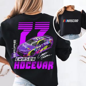 May include: Black sweatshirt with a colourful graphic of a race car, number 77, and the name Carson Hocevar. The text "Spire Motorsports" is also visible. A smaller image shows a black sweatshirt with the word "NASCAR."