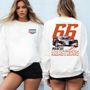 Könnte beinhalten: Weißes Sweatshirt mit Rundhalsausschnitt. Auf der Vorderseite befindet sich ein kleines MSR-Logo. Auf der Rückseite sind die Nummer 66, eine Rennwagen-Grafik und der Name "MARCUS ARMSTRONG" abgebildet.