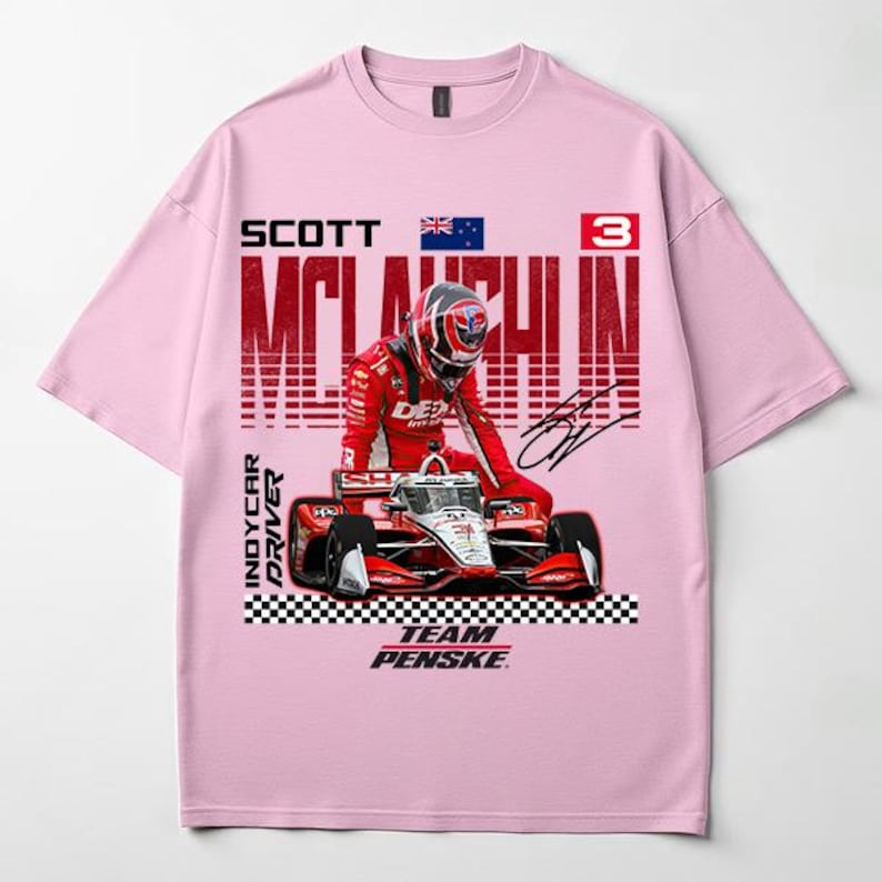 May include: Pink t-shirt featuring a graphic of an IndyCar driver in a red racing suit and helmet, with a race car. The text includes "SCOTT MCLAUGHLIN", "INDYCAR DRIVER", and "TEAM PENSKE".