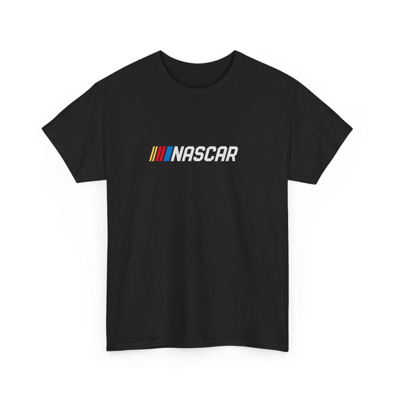 May include: Black t-shirt featuring the NASCAR logo. The logo includes three vertical stripes in red, yellow, and blue, followed by the word "NASCAR" in white. The shirt is a classic crew neck style.