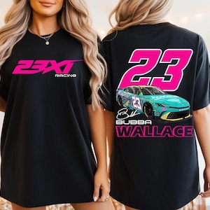 Könnte beinhalten: Ein schwarzes T-Shirt mit dem pinkfarbenen 23XI Racing-Logo auf der Vorderseite. Die Rückseite zeigt eine große pinkfarbene Nummer 23, einen türkisfarbenen und gelben Rennwagen, eine Unterschrift und den Text Bubba Wallace in fetter Schrift.