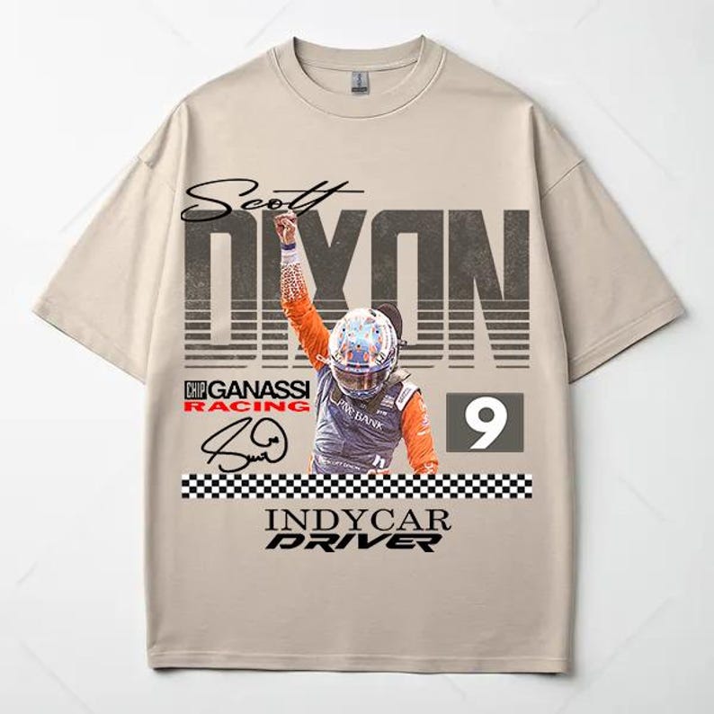 May include: Beige t-shirt featuring a graphic of IndyCar driver Scott Dixon. The design includes the driver's name, racing team logo, signature, and the number 9. The shirt has a crew neck and short sleeves.