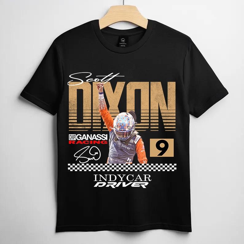 May include: Black t-shirt featuring a graphic of IndyCar driver Scott Dixon. The design includes the driver's name, a racing helmet, the number 9, and the words "INDYCAR DRIVER". The shirt has a checkered flag design at the bottom.