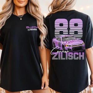 May include: Black short-sleeved t-shirt featuring the text "ZILISCH" and a logo on the front. The back of the shirt displays the number "98" in a striped design, a purple race car graphic, and the name "Connor ZILISCH".